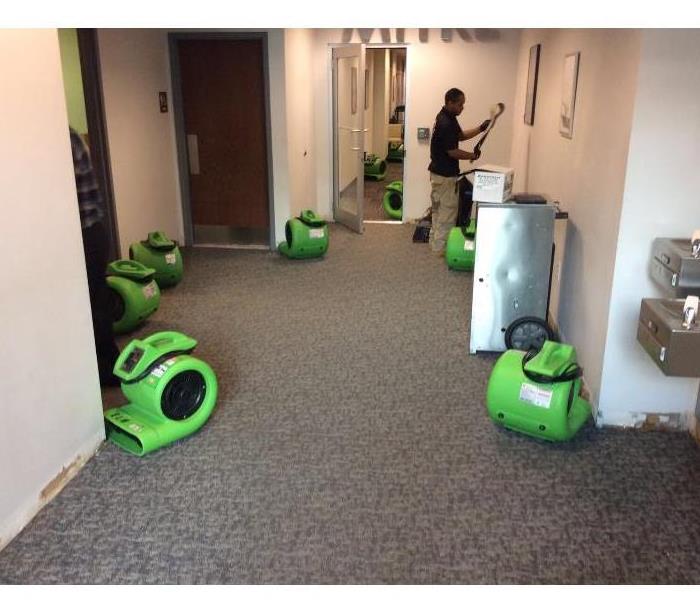 Man and air movers placed throughout hallway